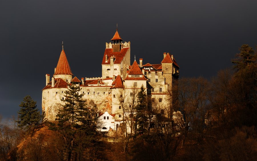 Bran Castle during the night. Maiestuos building with a black sky in the background