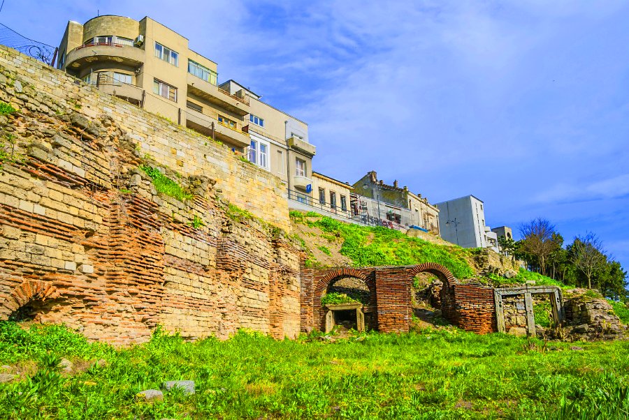 The Roman Edifice from Constanta with vegetation around and a blue beautiful sky